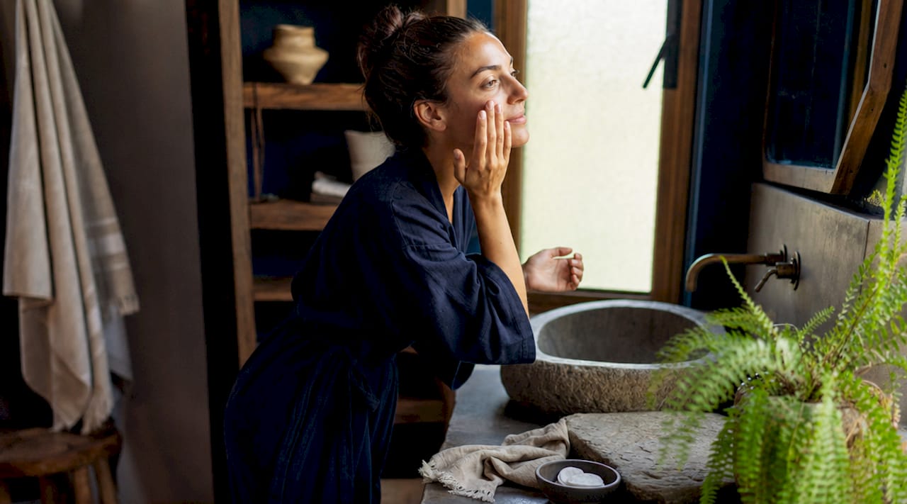 Woman applying serum in bright home setting