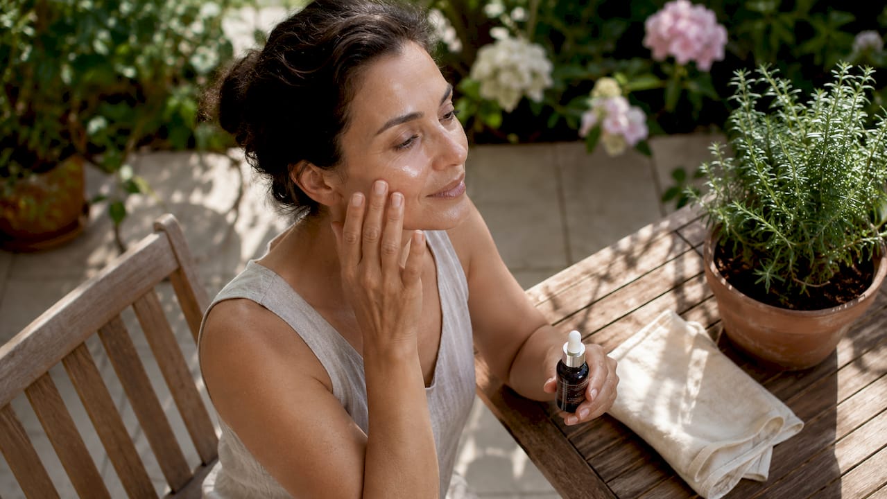 Woman applying serum to delicate skin