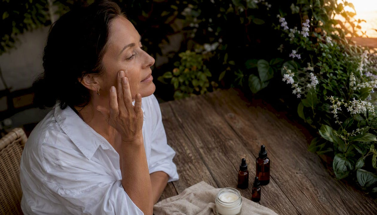 Woman applying brightening serum at home vanity
