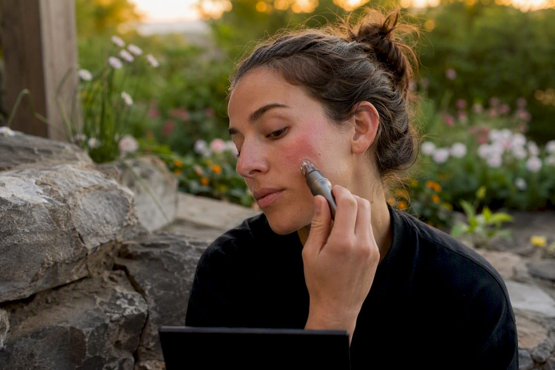 Person performing at-home microneedling on cheek